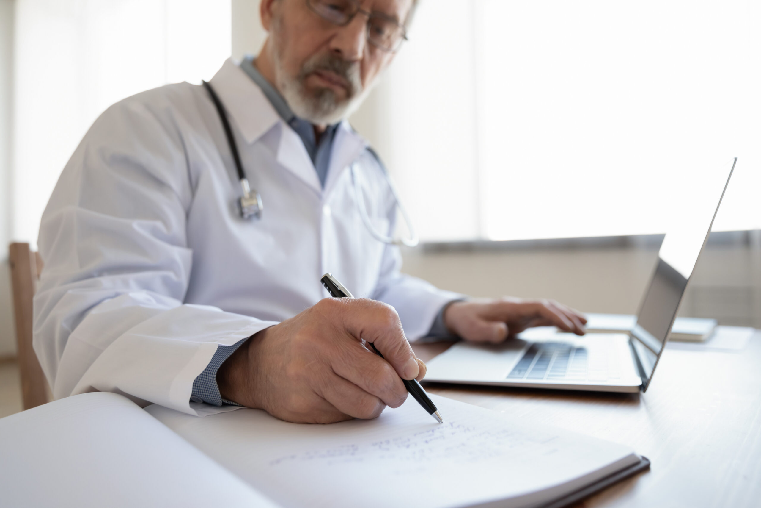 Close,Up,Of,Elderly,Grey-haired,Male,Doctor,Or,Gp,Sit