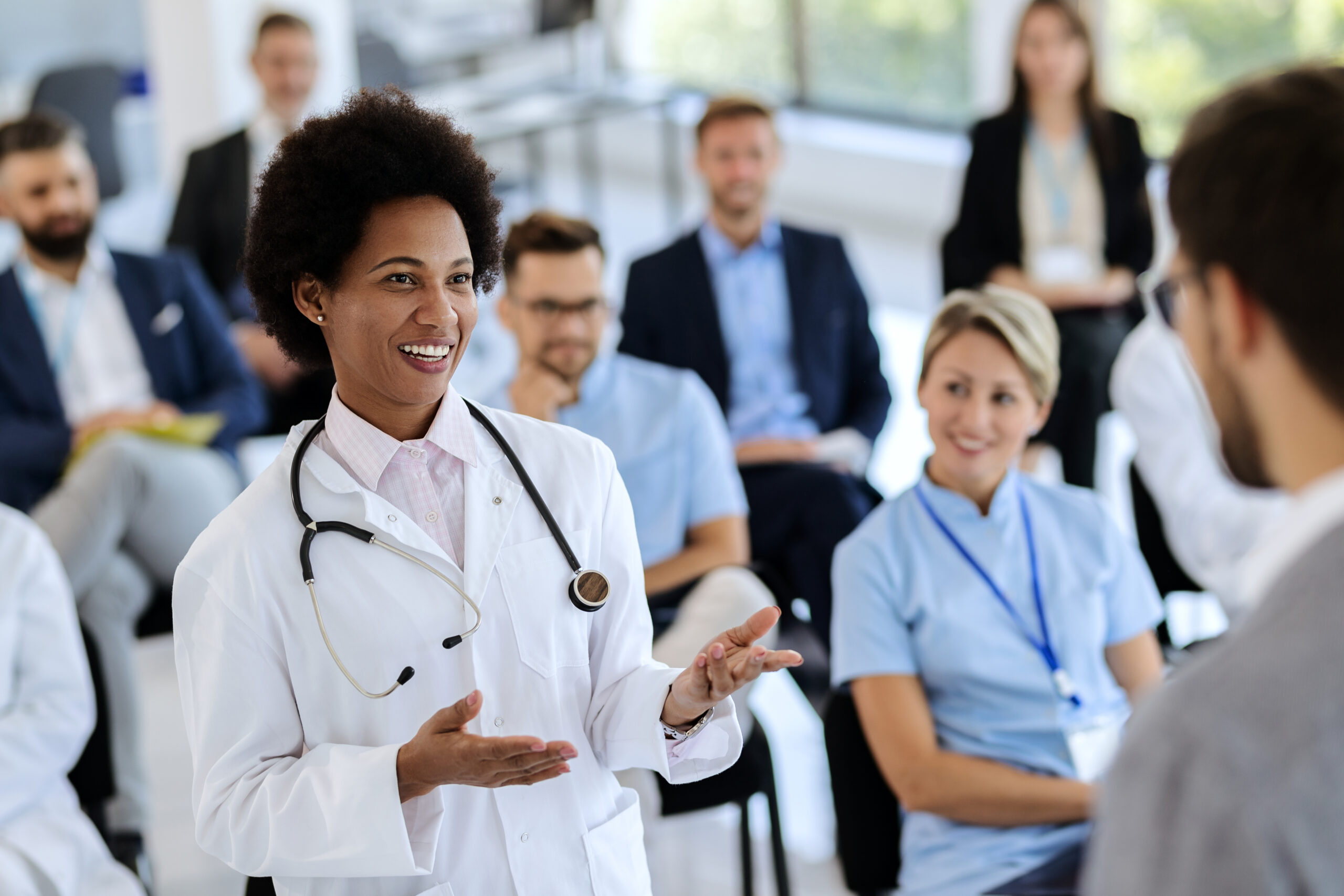 Happy,African,American,Female,Doctor,Talking,To,A,Businessman,Who