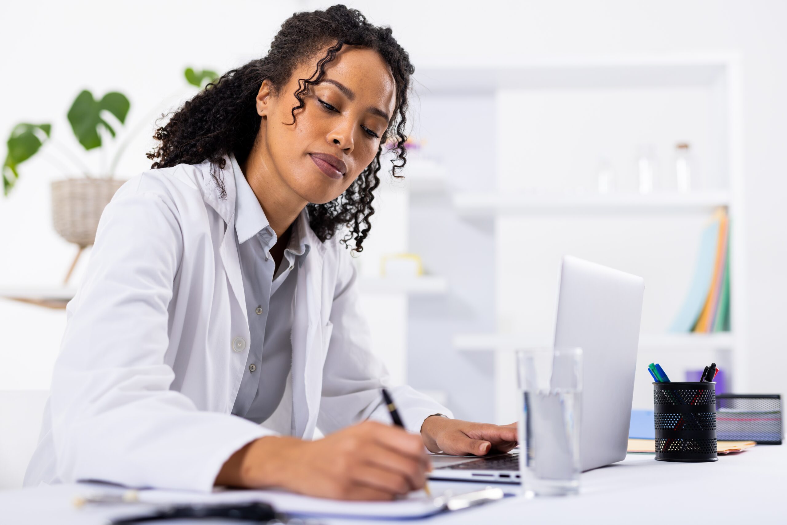 African,American,Mid,Adult,Female,Doctor,Writing,On,Clipboard,While
