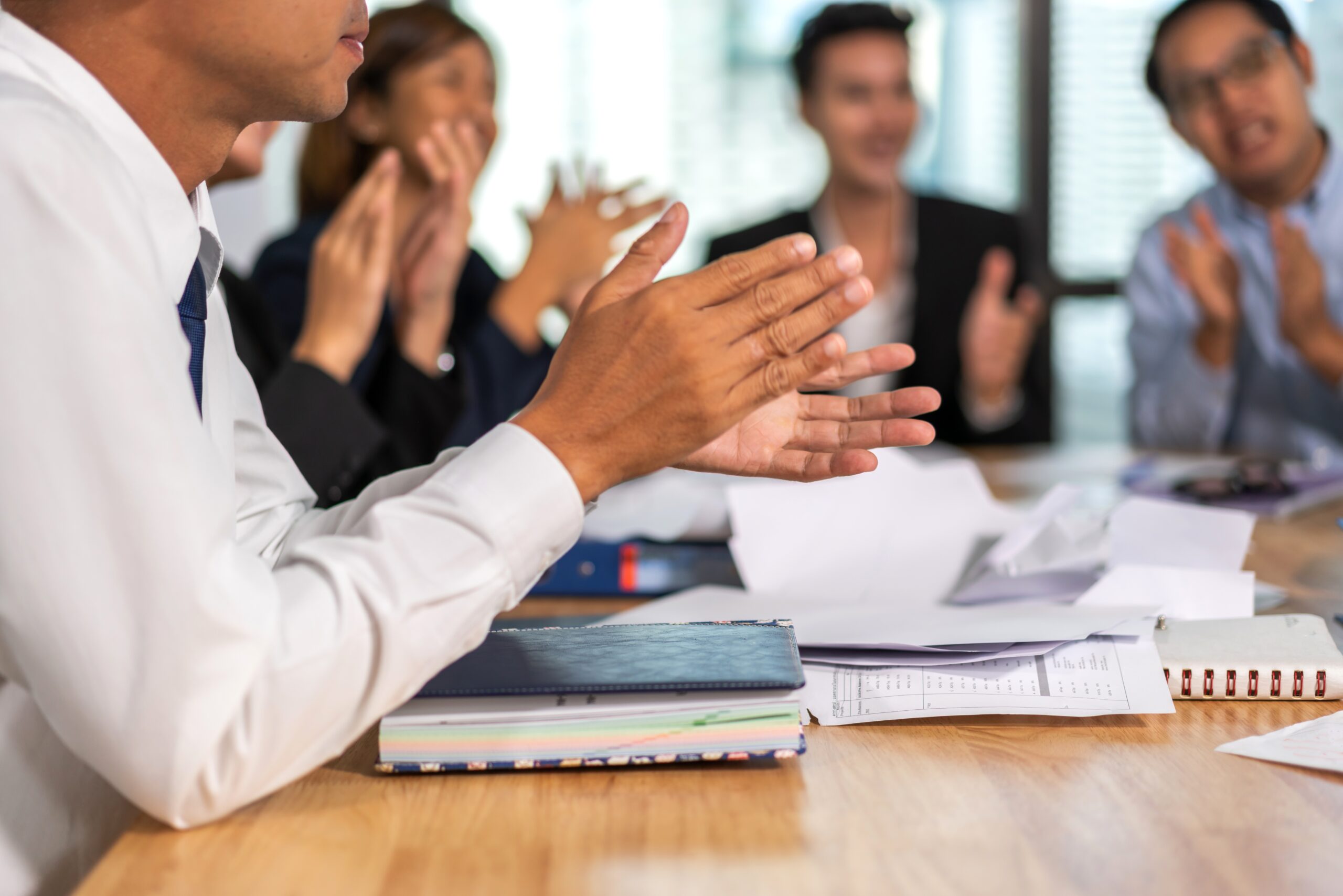 Colleagues at a meeting clapping hands