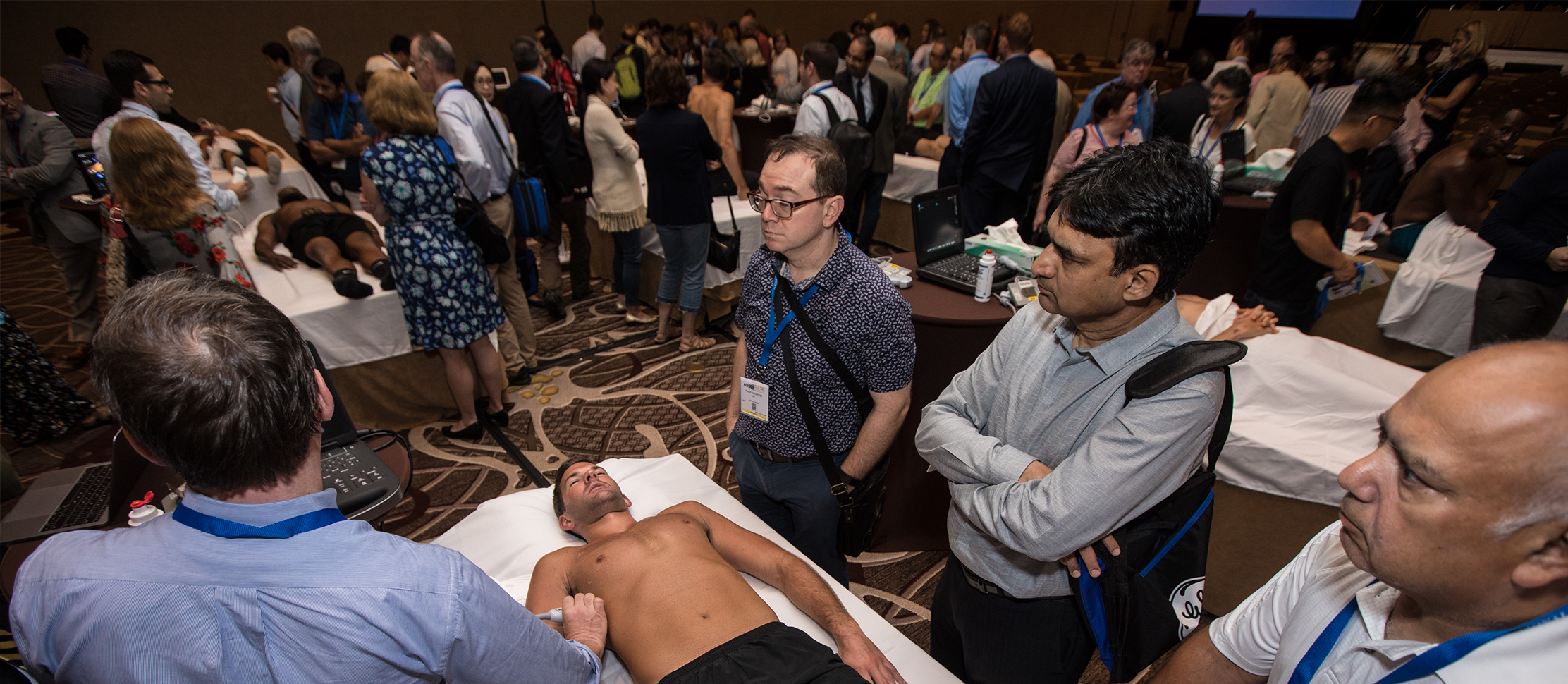 Doctor scanning patient in room of people